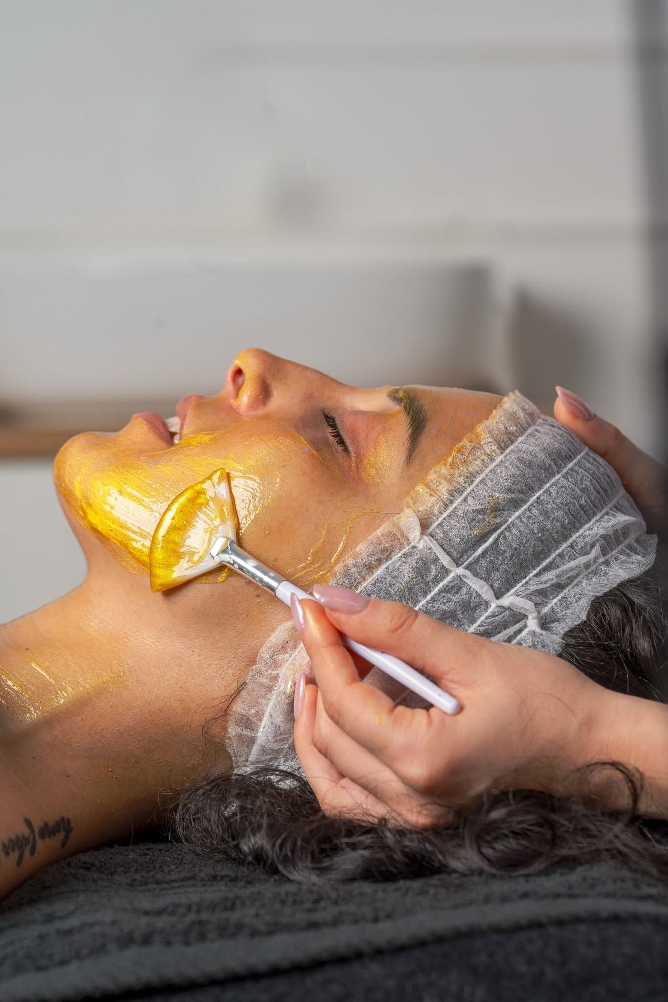 Maschera dorata applicata durante un trattamento viso